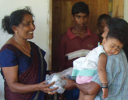 Photo of Mrs. Prem presenting a piece of new fishing net to a Sri Lankan Tsunami widow